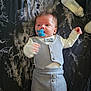 baby, pacifier, bottle, clothing, bow_tie, blanket, infant, cute, lying_down, blue, grey, marble_pattern, newborn, baby_outfit, small_hands, bed, soft_lighting, indoors, child, face