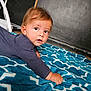 toddler, child, baby, blanket, blue, pattern, indoor, curious, face, expression, long_sleeve, floor, crawling, young, person, skin, hair, hand, portrait, cozy