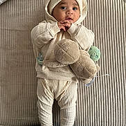 Ilyass participe au concours pour gagner de l'argent avec cette photo : baby, infant, plush_toy, turtle, knit_hat, knit_pants, hoodie, socks, beige, soft_texture, blanket, floor, curious_expression, cute, child, lying_down, indoors, portrait, warm_clothing, baby_clothes