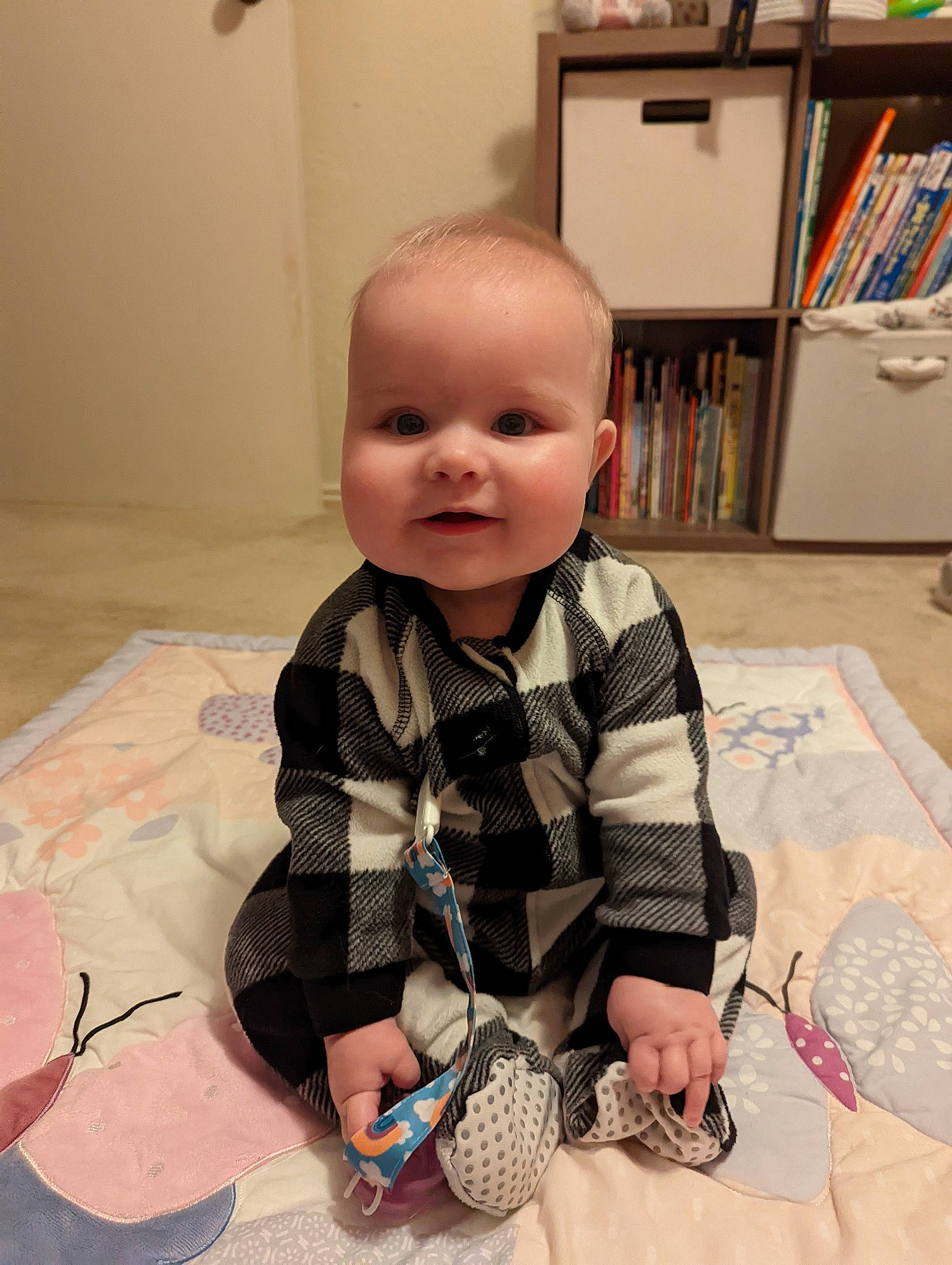 Addy joined the competition — help win amazing prizes! arm, baby, baby_toddler_clothing, bookcase, cheek, child, comfort, face, flooring, fun, mouth, nail, pattern, person, picture_frame, shelf, shelving, sitting, sleeve, t_shirt