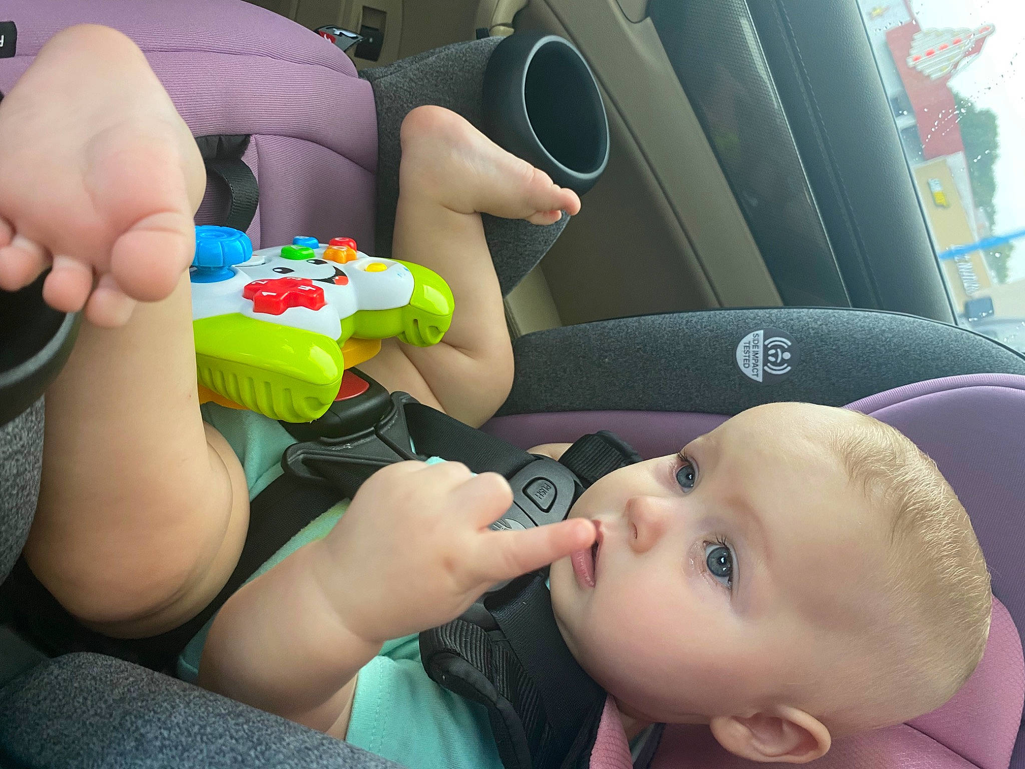 Alina is registered to the contest to win money with this photo: auto_part, baby, baby_products, car_seat, child, eyelash, finger, fun, gesture, green, hand, happy, human_leg, leisure, nail, person, thigh, thumb, toddler, toy