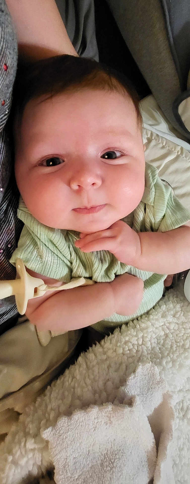Riley is registered to the contest to win money with this photo: baby, infant, face, hand, pacifier, blanket, clothing, cute, skin, expression, person, resting, indoors, closeup, young, child, soft, comfort, sleepy, cozy
