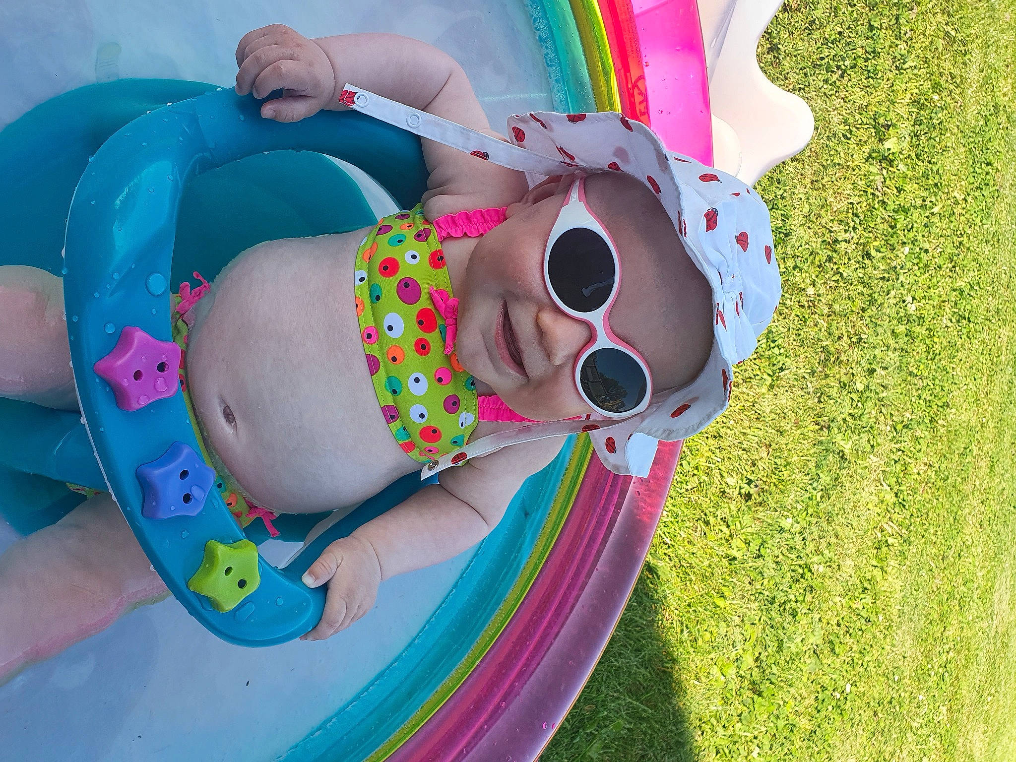 Eva a rejoint le concours — aidez-le/la à gagner de superbes lots ! baby, child, circle, design, eyewear, facial_expression, fun, goggles, grass, happy, headwear, leisure, magenta, pattern, person, pink, product, recreation, smile, sunglasses