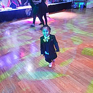 Zon'Jei is registered to the contest to win money with this photo: child, toddler, suit, bow_tie, dance_floor, party, disco_lights, hardwood_floor, stage, musicians, adults, dancing, formal_wear, colorful_lights, event, indoor, smile, single_child, spotlight, celebration