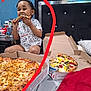 child, toddler, pizza, pizza_box, bed, headboard, scribble, red_mark, eating, bite, shirt, table, toy, pillow, smiling, hands, food, cardboard, seat, interior