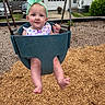 Stella joined the competition — help win amazing prizes! baby, child, swing, playground, headband, tongue_out, wood_chips, outdoor, smiling, park, blue_swing, green_headband, infant, play, happy, person, summer, casual_clothing, residential_area, daytime