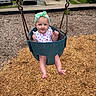 baby, child, toddler, swing, playground, headband, outdoor, woodchips, sitting, smiling, clothing, park, play, person, fun, summer, casual, daylight, happy, cute