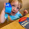 Leo joined the competition — help win amazing prizes! toddler, child, blue_box, table, tie_dye_shirt, dairy_queen, food_box, indoor, curious, playful, face, hand, mouth_open, light_brown_hair, floor_tiles, wooden_table, sitting, person, young_child, casual_clothing