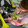 adult, aircraft, child, cockpit, controls, curious, glasses, headband, indoor, interaction, joystick, machine, person, playful, seat, seatbelt, shorts, technology, tshirt, yellow