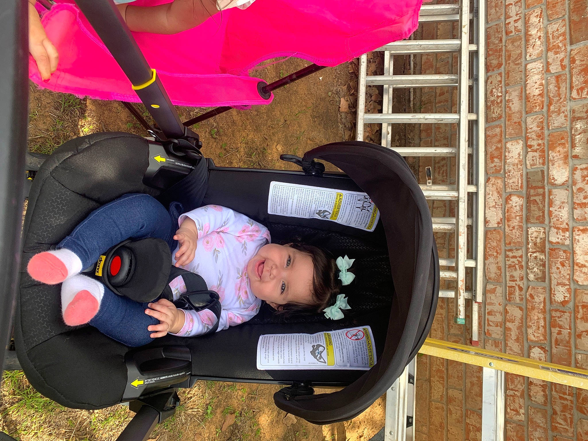 Lucia is registered to the contest to win money with this photo: baby, baby_carriage, baby_products, baby_toddler_clothing, brick, brickwork, child, comfort, fashion_accessory, fun, hat, joy, lap, magenta, person, plant, sitting, toddler, tree