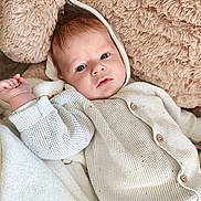 Lubin participe au concours pour gagner de l'argent avec cette photo : baby, blanket, cozy, cushion, cute, expression, eyes, face, hand, hood, indoor, infant, knitted_sweater, lying_down, plush, portrait, relaxed, soft_texture, warm_clothing, young_child