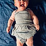 baby, infant, child, smiling, laughing, headband, yellow, clothing, grey, blanket, blue, skin, barefoot, cute, happy, portrait, lying_down, indoors, human, person