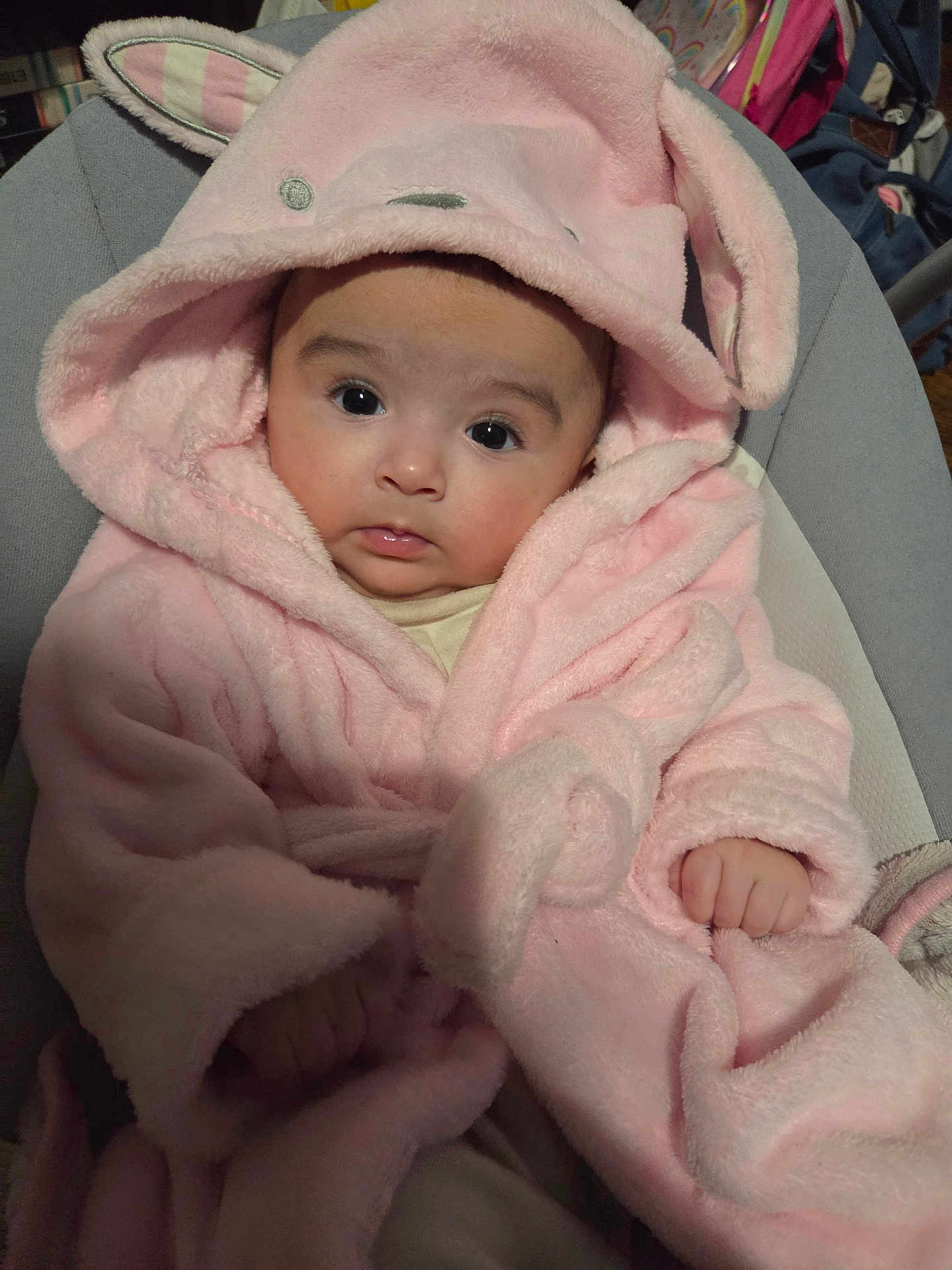 Lya participe au concours pour gagner de l'argent avec cette photo : baby, infant, pink_robe, bunny_ears, cute, fluffy, child, portrait, indoors, cushion, seat, hooded_clothing, soft_texture, small_hands, wide_eyes, person, young_child, warm_clothing, expression, adorable