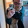 Pattenrond participe au concours pour gagner de l'argent avec cette photo : person, cat, selfie, glasses, orange_cat, indoor, phone, sticker, hand, sweater, cozy, feline, blurred_background, cute, pet, portrait, holding, warm, home, casual