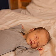 Gaspar a rejoint le concours — aidez-le/la à gagner de superbes lots ! baby, sleeping, bed, gray_clothing, knitwear, infant, soft_bedding, peaceful, rest, person, indoors, wooden_furniture, portrait, child, cute, newborn, cozy, relaxation, head, face