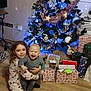 Thelio participe au concours pour gagner de l'argent avec cette photo : child, children, baby, christmas_tree, presents, holiday, celebration, smiling, happy, decorations, indoors, floor, gift_wrap, festive, tree_lights, ornaments, sitting, hugging, family, cozy