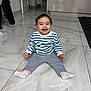 Janah participe au concours pour gagner de l'argent avec cette photo : toddler, child, smiling, indoor, floor, tile, sweater, pants, socks, happy, person, baby, home, door, cabinet, curly_hair, seated, cute, young, playful
