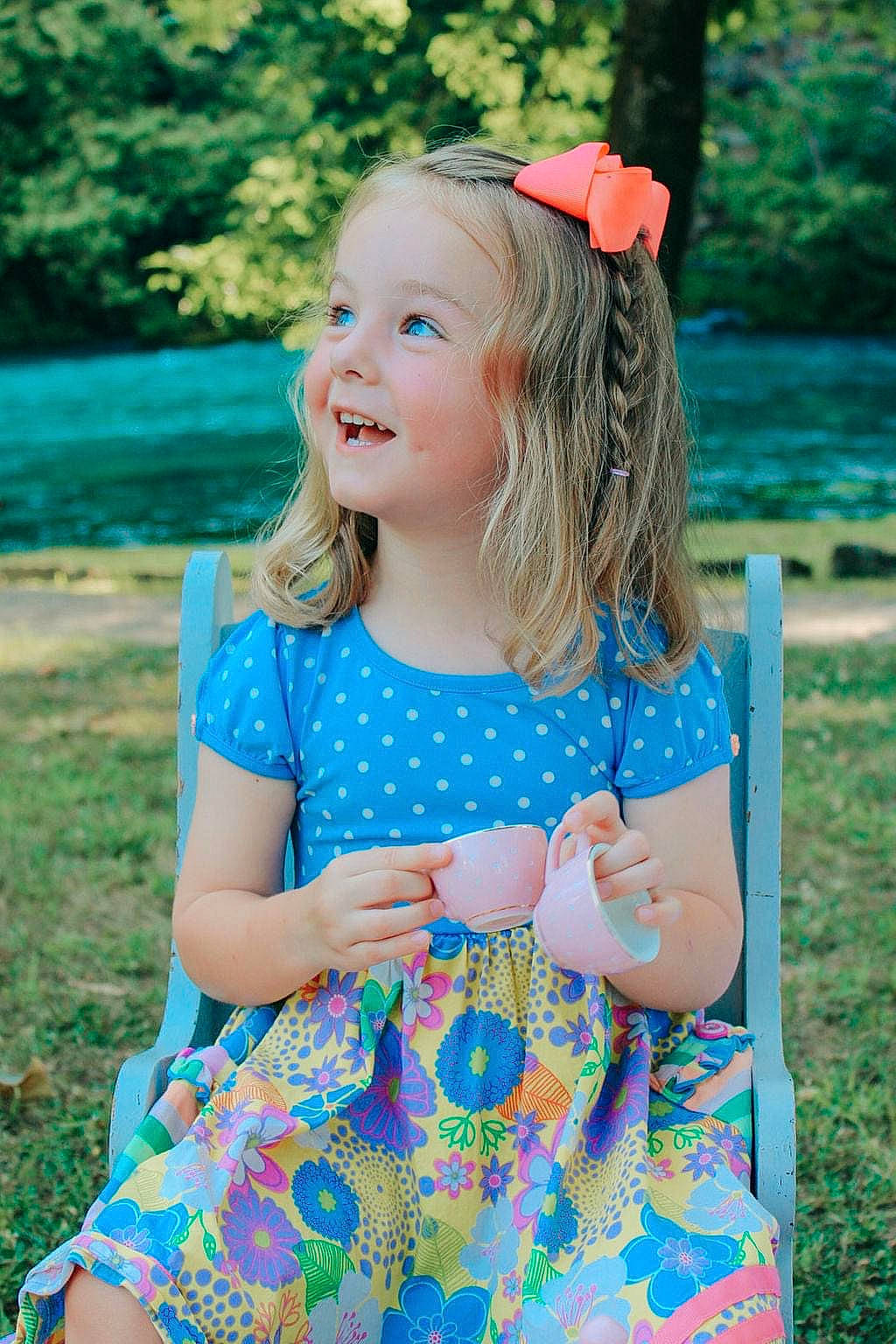 Gwendolyn is registered to the contest to win money with this photo: azure, baby_toddler_clothing, blue, dress, face, fashion, green, hair, hairstyle, happy, headwear, joy, leaf, people_in_nature, person, photograph, pink, plant, skin, sleeve