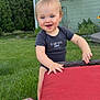 Caysen is registered to the contest to win money with this photo: baby, blue_eyes, child, cushion, daylight, grass, greenery, happy, house, lawn, onesie, outdoor, person, playing, quilt, red, smiling, toddler, trees, window