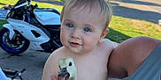 Caysen is registered to the contest to win money with this photo: animal, baby_goose, blue_eyes, casual, child, cute, grass, happy, holding, motorcycle, nature, outdoor, person, portrait, street, summer, sunlight, tattoo, toddler, tree