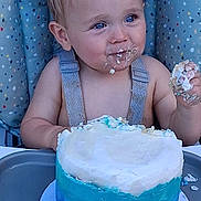 Caysen is registered to the contest to win money with this photo: birthday, blonde_hair, blue_eyes, cake, celebration, child, cushion, face, food, frosting, hand, happy, high_chair, messy, party, polka_dot, sitting, smile, table, toddler
