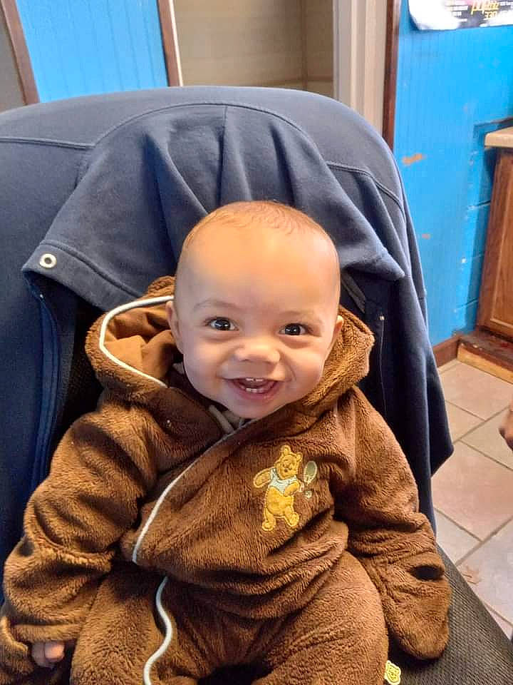 Isiah is registered to the contest to win money with this photo: baby, baby_toddler_clothing, cabinetry, cheek, child, curtain, eye, flooring, fun, fur, happy, headgear, home_appliance, joy, outerwear, person, room, sitting, sleeve, smile