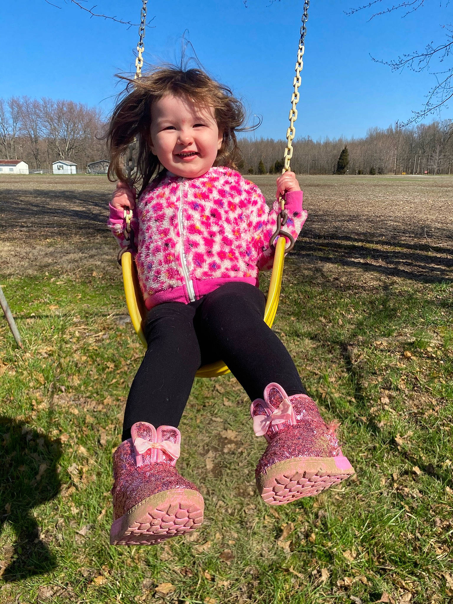 Emmalyn is registered to the contest to win money with this photo: baby_toddler_clothing, child, city, face, fun, grass, happy, human_body, joy, leisure, people_in_nature, person, pink, plant, playground, recreation, sky, sleeve, smile, swing