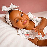 Isla is registered to the contest to win money with this photo: baby, blanket, bow, cherry_embroidery, child, closeup, crochet, cute, expression, face, happy, headband, indoors, infant, lying_down, portrait, skin, smile, soft_texture, white_clothing