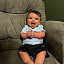 baby, child, smiling, happy, clapping, sitting, armchair, furniture, indoors, casual_clothing, shorts, tshirt, barefoot, cute, infant, portrait, person, young_child, expression, cozy