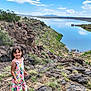 adventure, child, clouds, daytime, dress, girl, grass, happy, lake, landscape, mountains, nature, outdoor, rocks, scenery, shoes, sky, smile, sunny, water