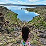 Myla is registered to the contest to win money with this photo: calm, child, clouds, colorful, daytime, dress, girl, grass, hills, lake, landscape, long_hair, mickey_mouse, nature, outdoor, rocks, scenic, sky, standing, water
