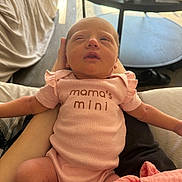 Eloise is registered to the contest to win money with this photo: newborn, baby, pink_onesie, infant, person, sleepy, indoor, table, medicine_bottles, blanket, arm, resting, cute, human, small, clothing, baby_girl, soft_light, casual, relaxing