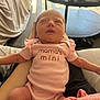 newborn, baby, pink_onesie, infant, person, sleepy, indoor, table, medicine_bottles, blanket, arm, resting, cute, human, small, clothing, baby_girl, soft_light, casual, relaxing