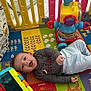Jose is registered to the contest to win money with this photo: baby, playmat, toy, playpen, colorful, child, smiling, indoor, floor, happy, infant, clothing, plastic, fun, cute, lying_down, early_childhood, play, bright, young_child