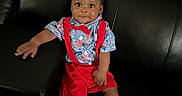 Tajhire is registered to the contest to win money with this photo: baby, blue_shirt, bow_tie, child, comfortable, couch, cute, face, footwear, furniture, hand, indoor, infant, leather_couch, looking, portrait, red_suspender, sitting, smile, socks