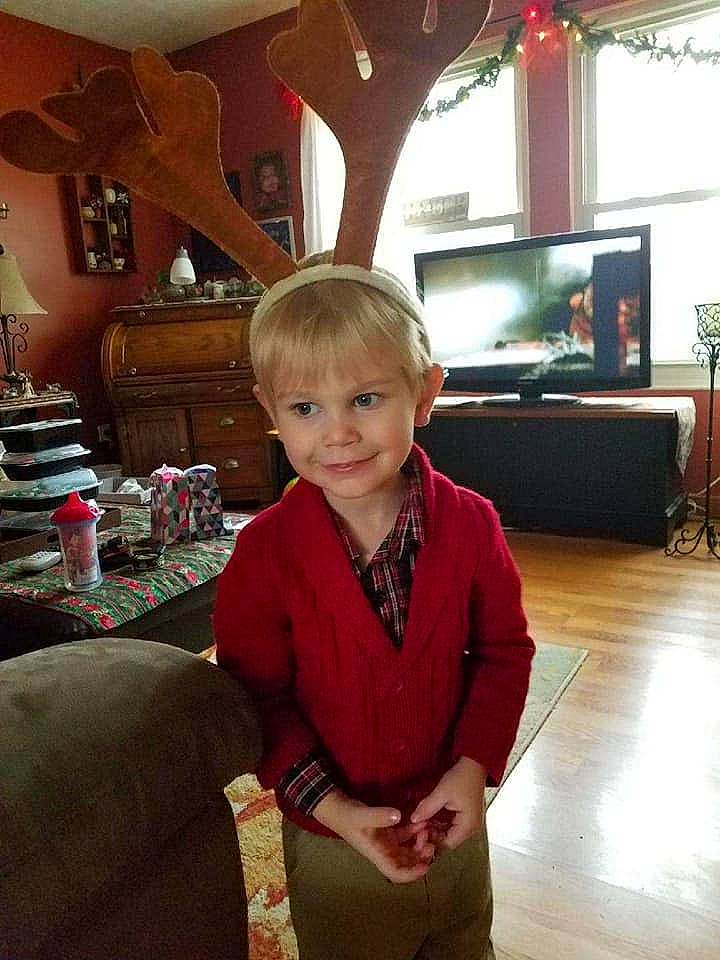 Travis is registered to the contest to win money with this photo: child, christmas, fun, person, restaurant, sitting, vacation