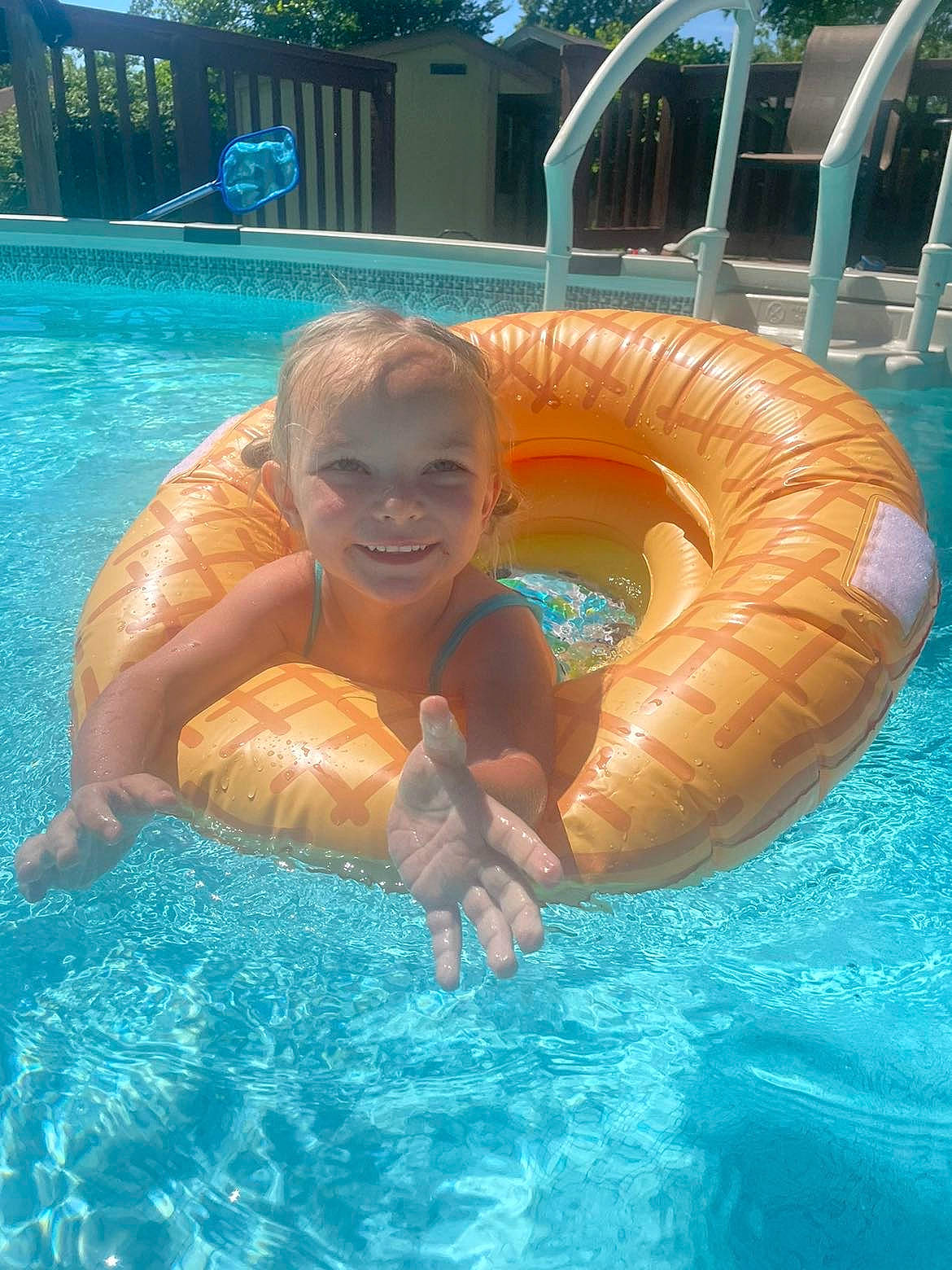 Karsyn is registered to the contest to win money with this photo: aqua, bathing, blue, child, fun, games, inflatable, joy, leisure, leisure_centre, nonbuilding_structure, person, personal_protective_equipment, plant, recreation, smile, summer, swimming_pool, swimwear, toddler
