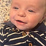Aidan is registered to the contest to win money with this photo: baby, infant, smiling, face, eyes, clothing, striped_sweater, button, closeup, portrait, lying_down, blanket, floral_pattern, cute, happy, young_child, skin, head, baby_girl, baby_boy