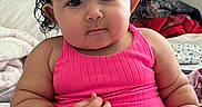 Kianna is registered to the contest to win money with this photo: baby, child, toddler, portrait, sitting, pink_dress, hair_clips, butterfly_clips, curly_hair, dark_hair, bedroom, bed, blanket, pillow, indoor, cute, serious_expression, infant, closeup, photography