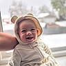 baby, child, smiling, hood, bear_ears, onesie, cozy, window, snow, winter, indoor, person, cute, joyful, soft, apparel, portrait, face, infant, warm