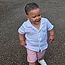 toddler, child, boy, white_shirt, pink_shorts, white_sneakers, bracelet, walking, outdoor, pavement, confident, short_hair, casual_clothing, daylight, cute, smiling, fashion, young, person, portrait