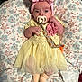baby, infant, pacifier, headband, bow, dress, yellow_dress, pink, flower_pattern, cushion, blanket, lying_down, cute, small_hands, clothing, newborn, indoors, soft_texture, sleepwear, child