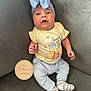 baby, infant, one_month, headband, bow, yellow_onesie, winnie_the_pooh, couch, gray_couch, striped_socks, wooden_milestone, milestone_marker, cute, portrait, seated, indoors, child, smiling, soft_lighting, cozy