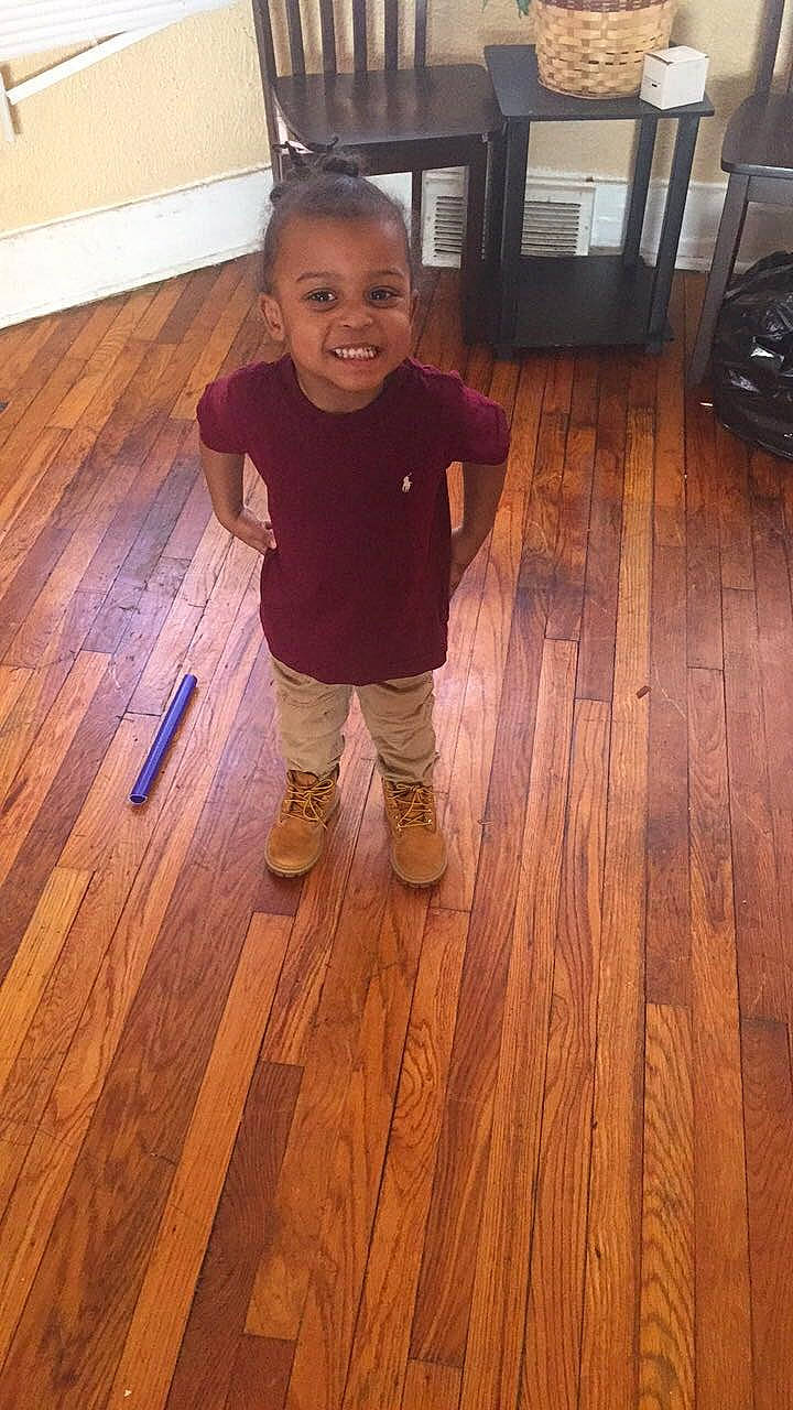 Tarrence is registered to the contest to win money with this photo: beauty, child, face, facial_expression, floor, flooring, hair, hardwood, head, joy, laminate_flooring, leg, nose, person, skin, smile, standing, toddler, varnish, wood