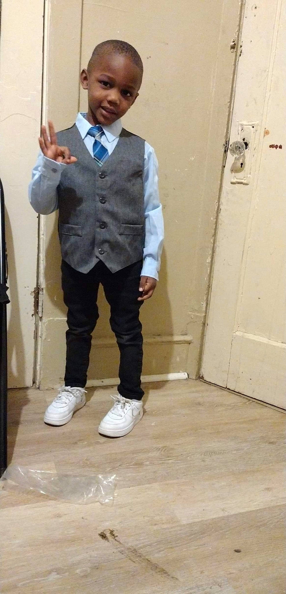 Malachi is registered to the contest to win money with this photo: blazer, bow_tie, button, collar, denim, door, dress_shirt, electric_blue, fashion_design, flooring, formal_wear, gesture, person, sleeve, smile, suit, tie, tuxedo, uniform, white_collar_worker