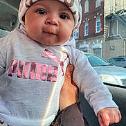Niyaleii is registered to the contest to win money with this photo: baby, child, infant, hat, clothing, puma, leopard_print, pink, sweatshirt, hand, car, window, city, buildings, daylight, face, portrait, cute, person, casual