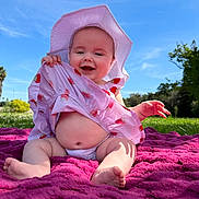 Avery joined the competition — help win amazing prizes! baby, child, smile, hat, dress, blanket, outdoor, grass, sunny, blue_sky, greenery, happy, sitting, infant, playful, nature, cute, summer, barefoot, portrait