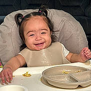 Cecilia joined the competition — help win amazing prizes! toddler, child, smiling, high_chair, pigtails, messy, food, meal, plate, bib, happy, indoor, person, cute, baby, face, table, eating, fun, expression
