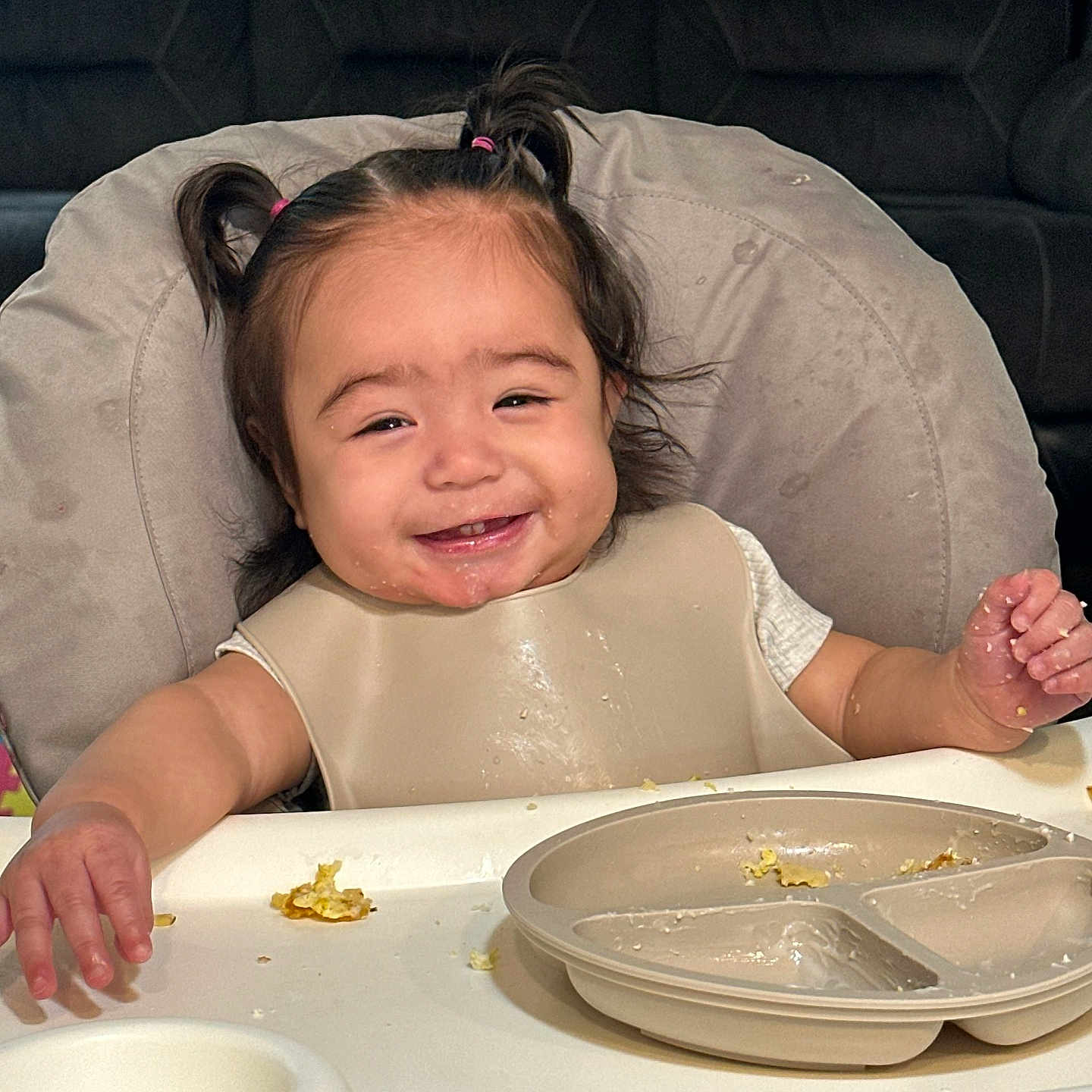 Cecilia joined the competition — help win amazing prizes! toddler, child, smiling, high_chair, pigtails, messy, food, meal, plate, bib, happy, indoor, person, cute, baby, face, table, eating, fun, expression