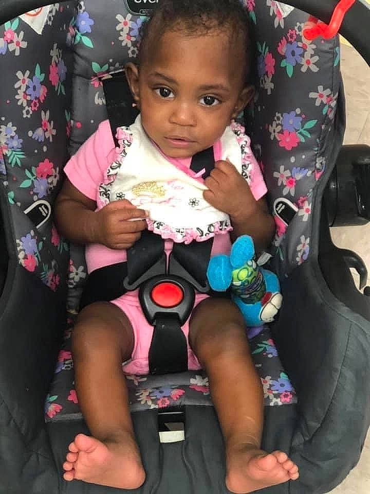 Khloè is registered to the contest to win money with this photo: baby, baby_carriage, baby_products, baby_toddler_clothing, black, car_seat, cheek, child, dress, event, finger, fun, hair, happy, nail, person, pink, sitting, skin, sleeve